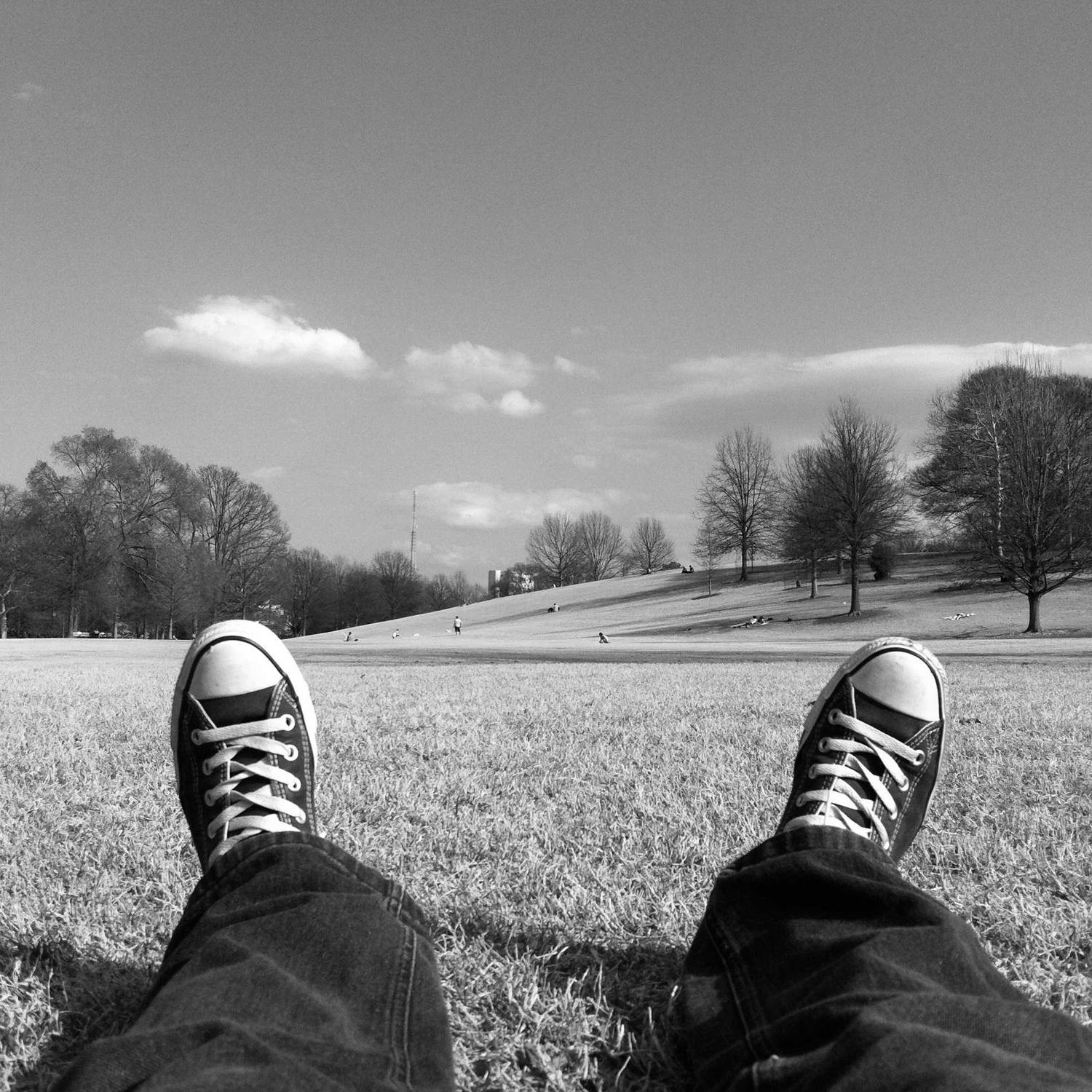 Sneakers crossed in the grass, low sun