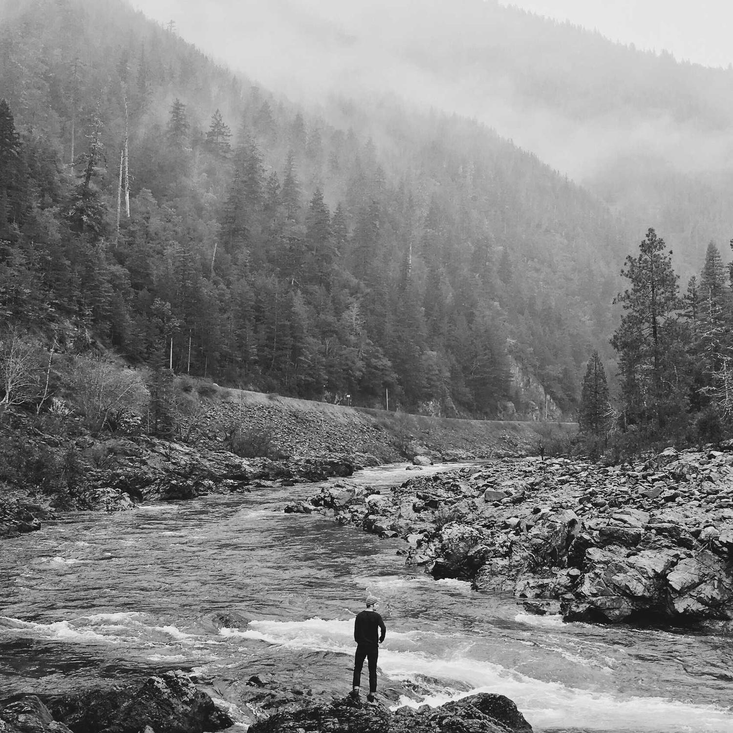 Small figure against a river valley, coat open