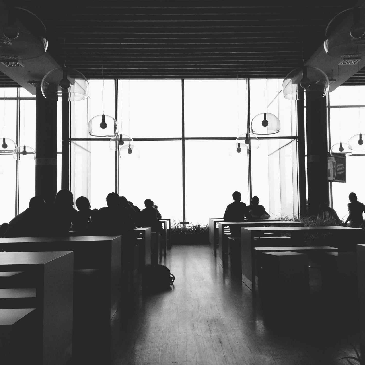 Figures at a café window, backlit
