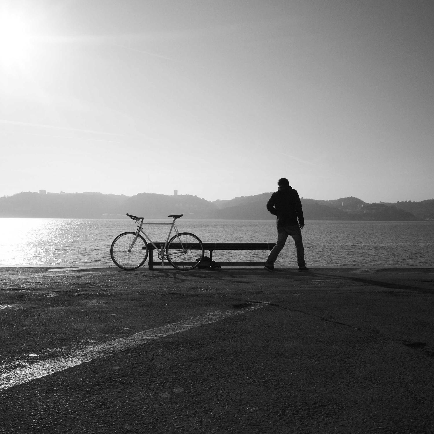 Silhouette with bicycle at the waterline