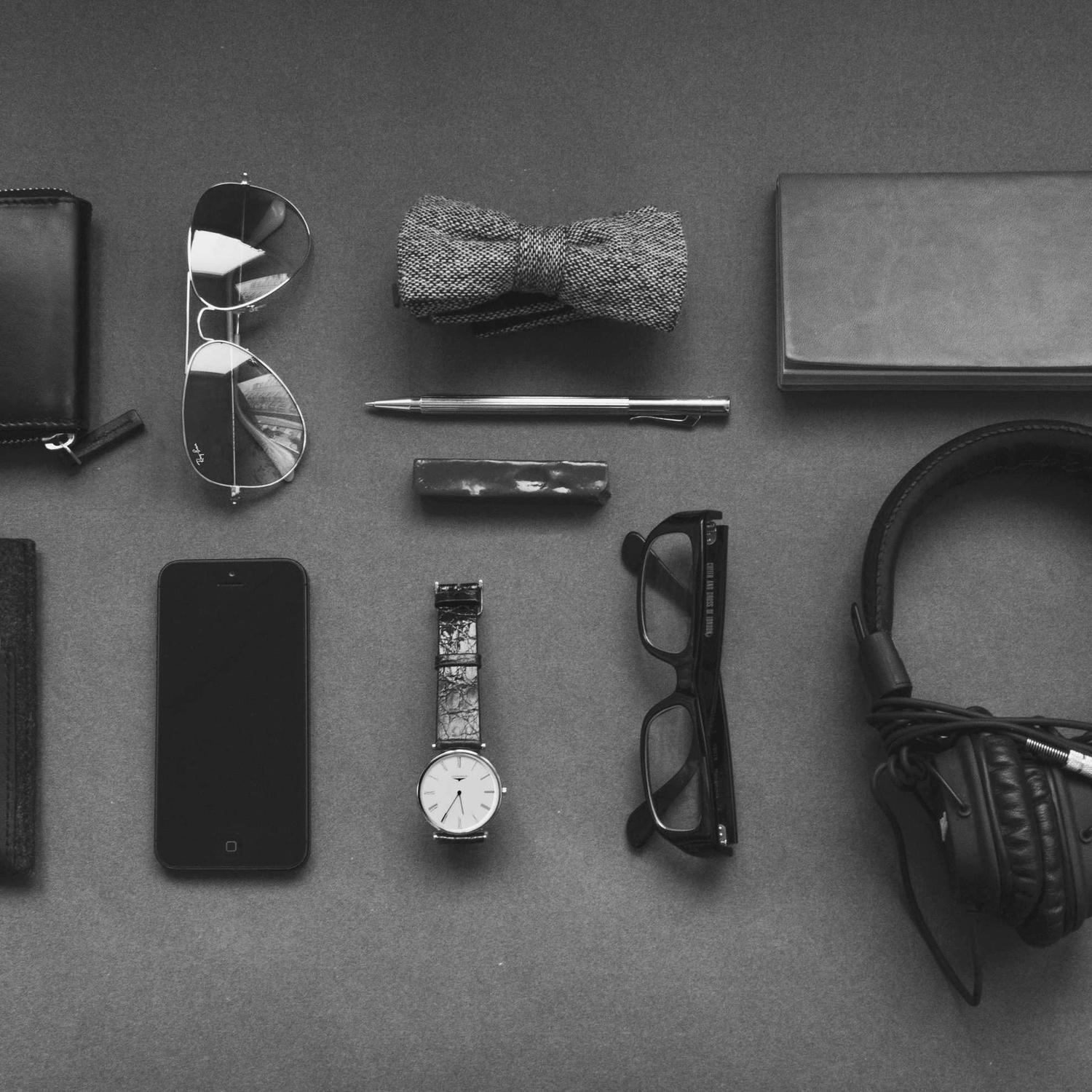 Flat lay of personal accessories on a table, monochrome