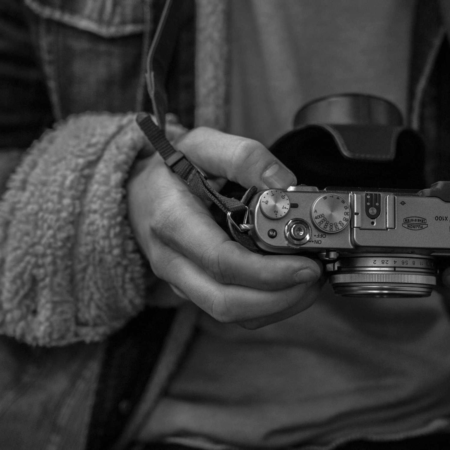 Hands cradling a rangefinder camera, rings in focus