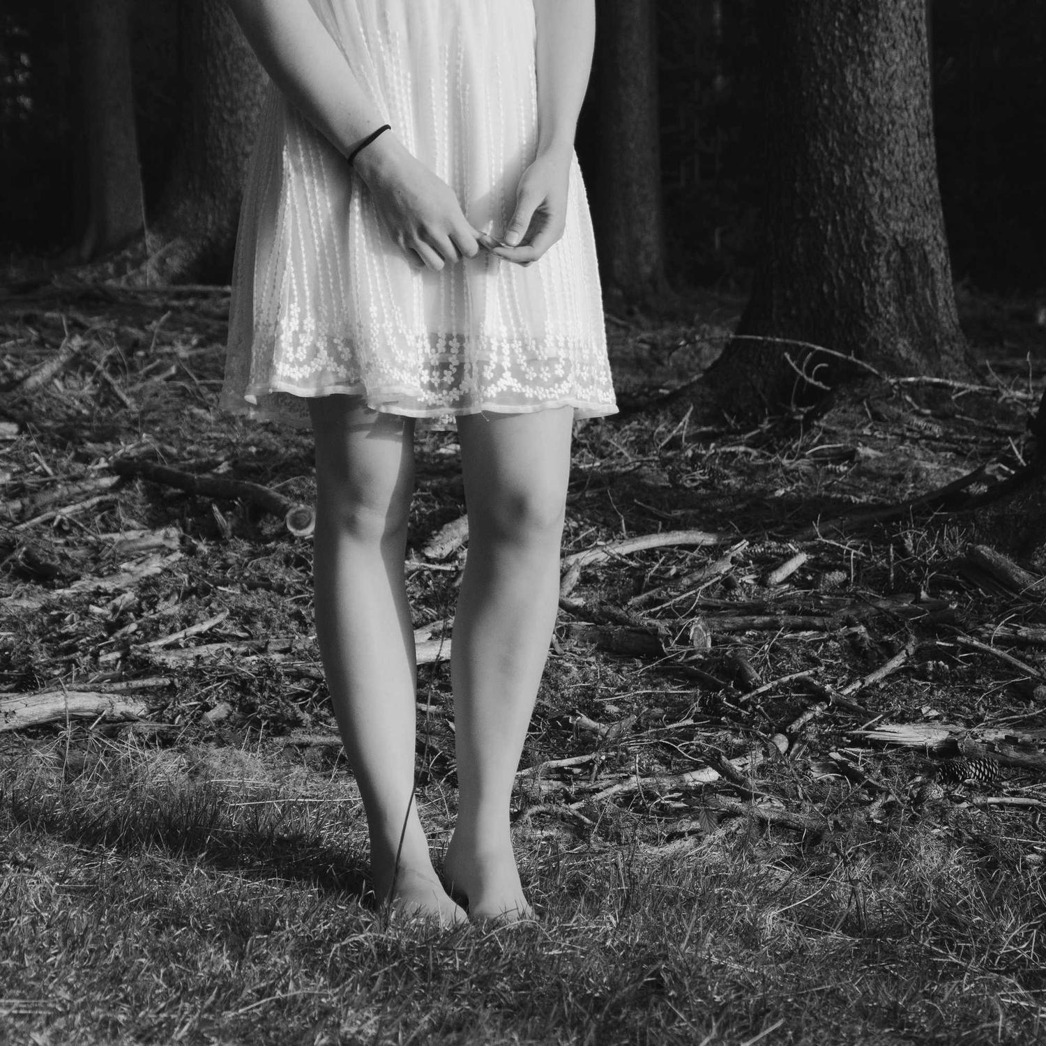 Seated model in structured coat, grain visible in the shadows