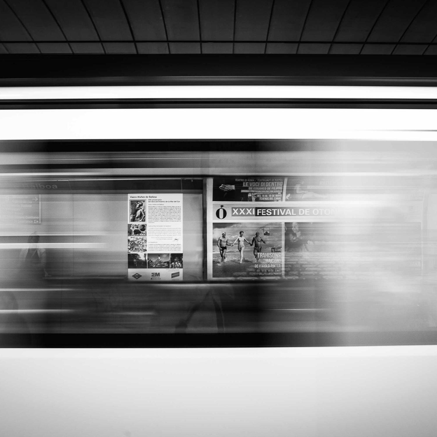 Motion-blurred figures through a lit corridor