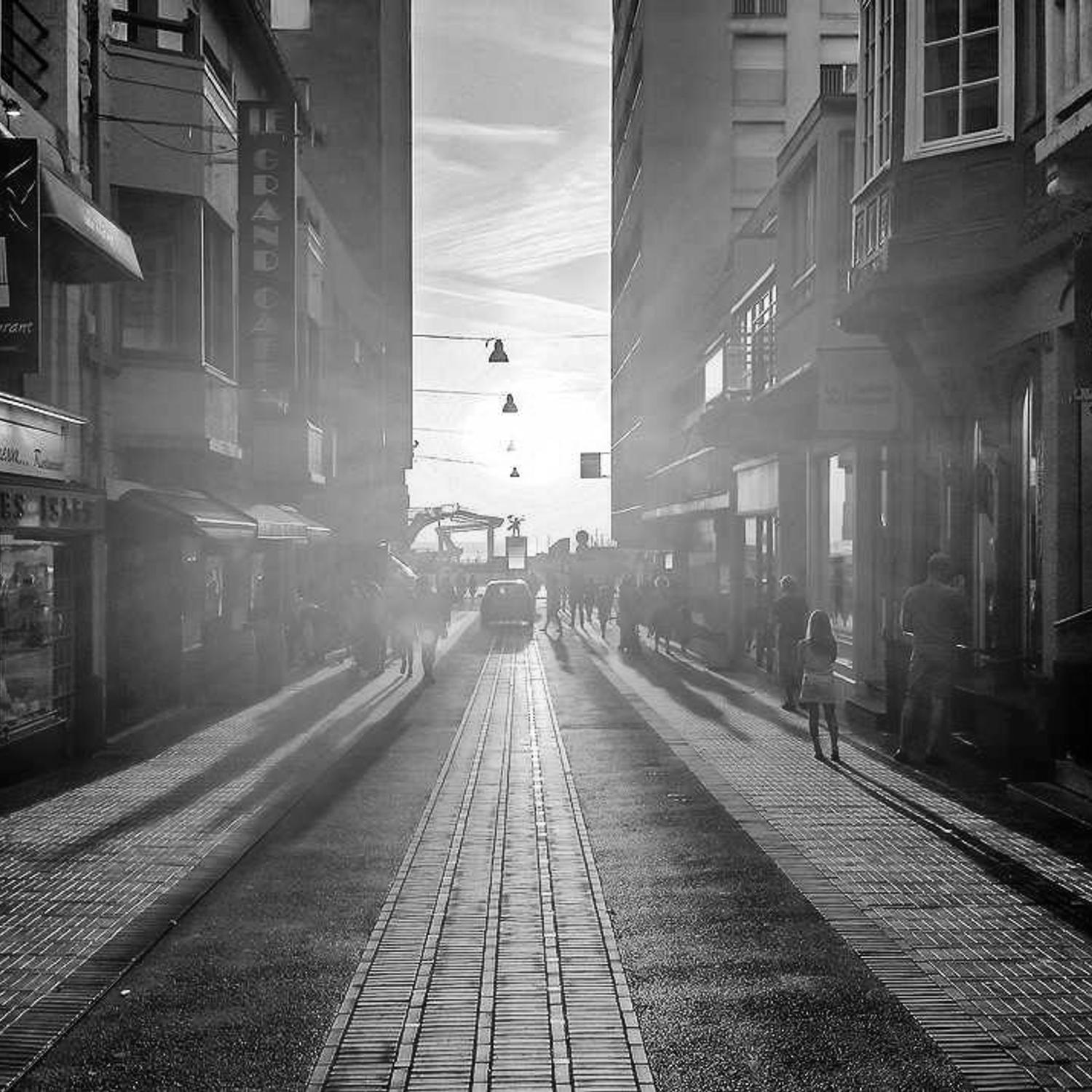 Figure on a sunlit road, long shadow
