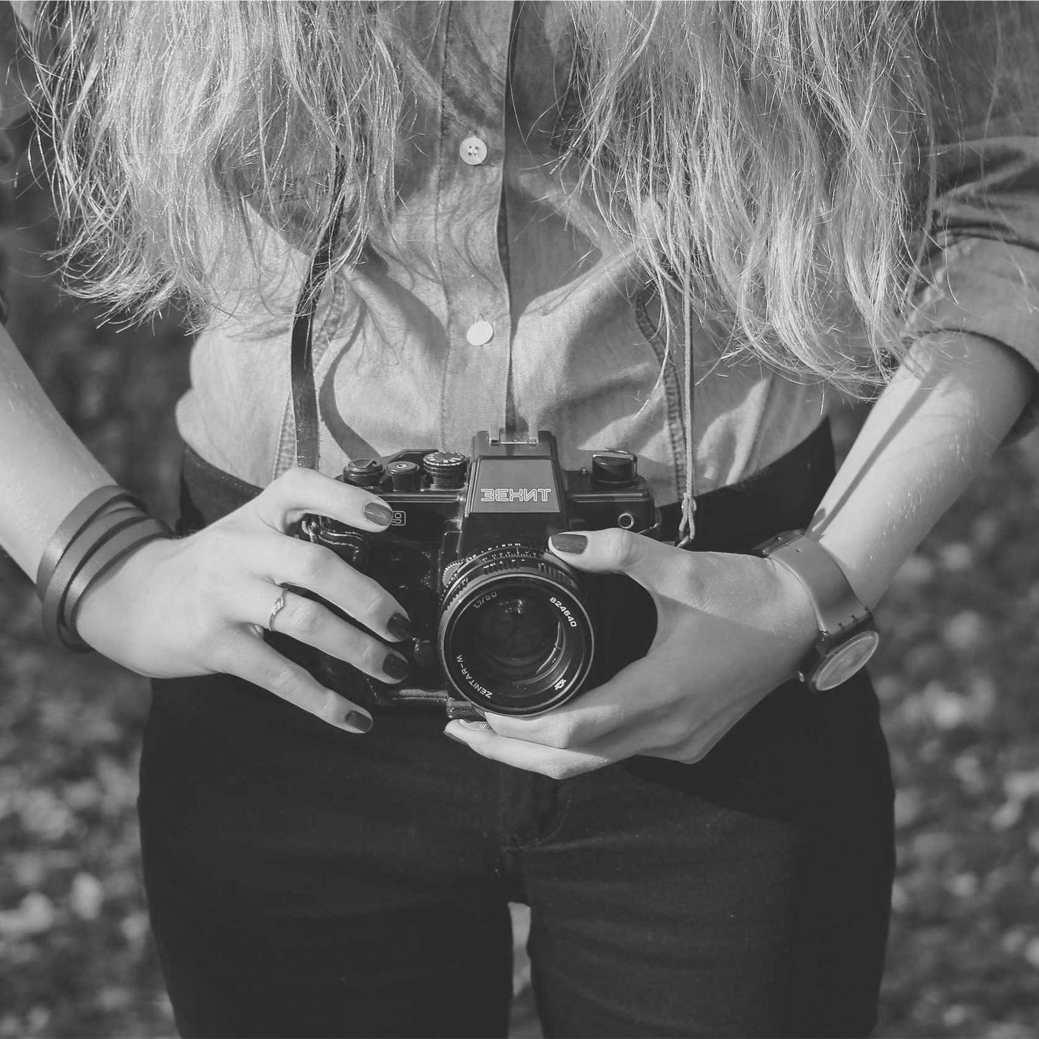 Torso with a film camera held at the waist